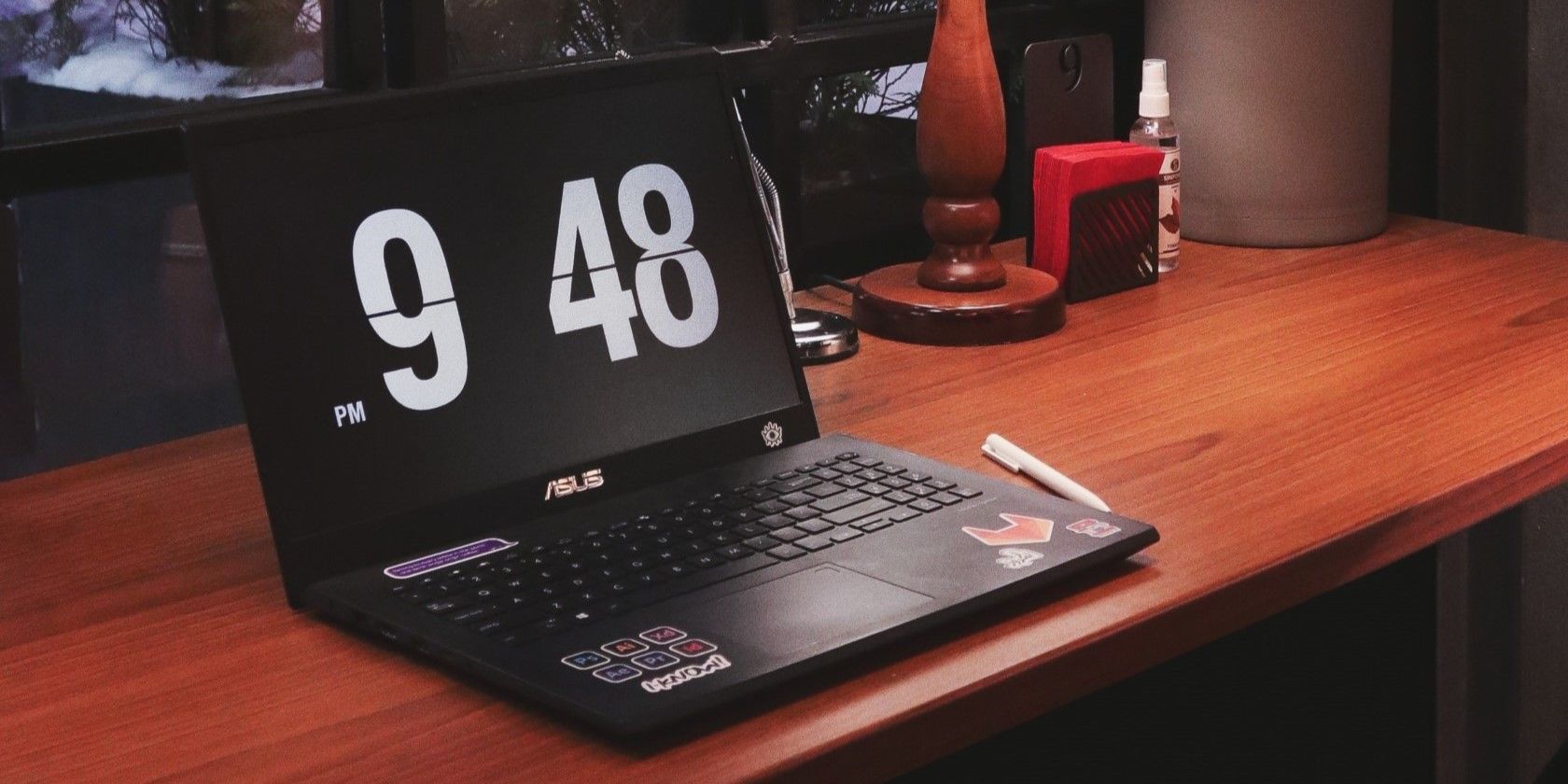 A black Asus laptop on a wooden table