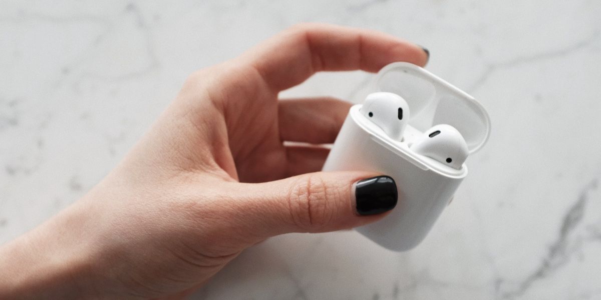 hand holding opened airpods case with airpods inside