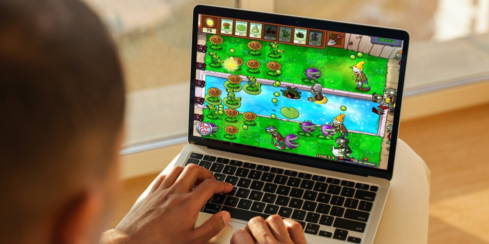MacBook user playing a strategy game