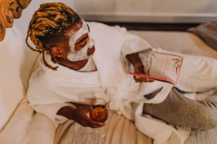 Man relaxing with a glass of wine and a book