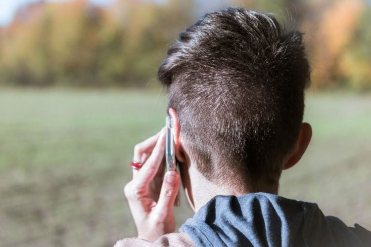 Woman talking on the phone with her back turned from the camera