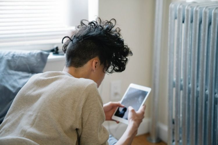 A young man looking at a tablet fully absorbed