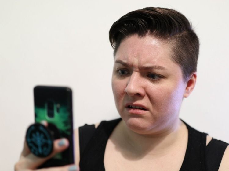 Woman looking at a phone looking upset