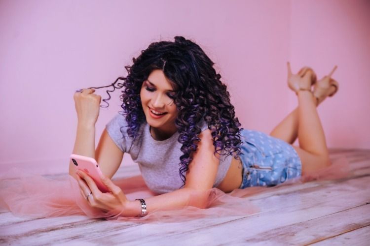 Young woman using her smartphone and smiling