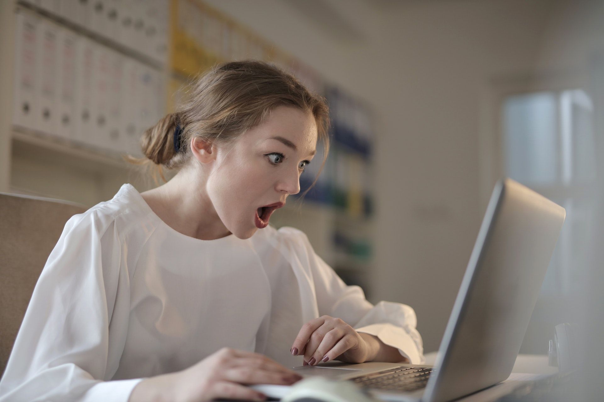 Woman shocked looking at her laptop screen