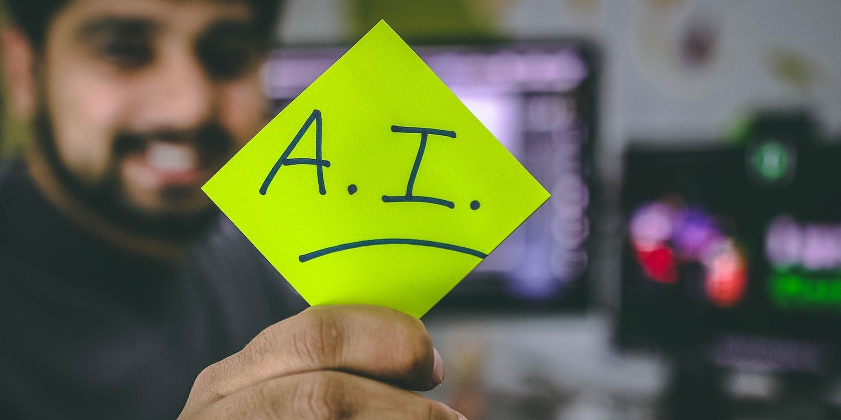 A hand holding a note with A.I written on it.