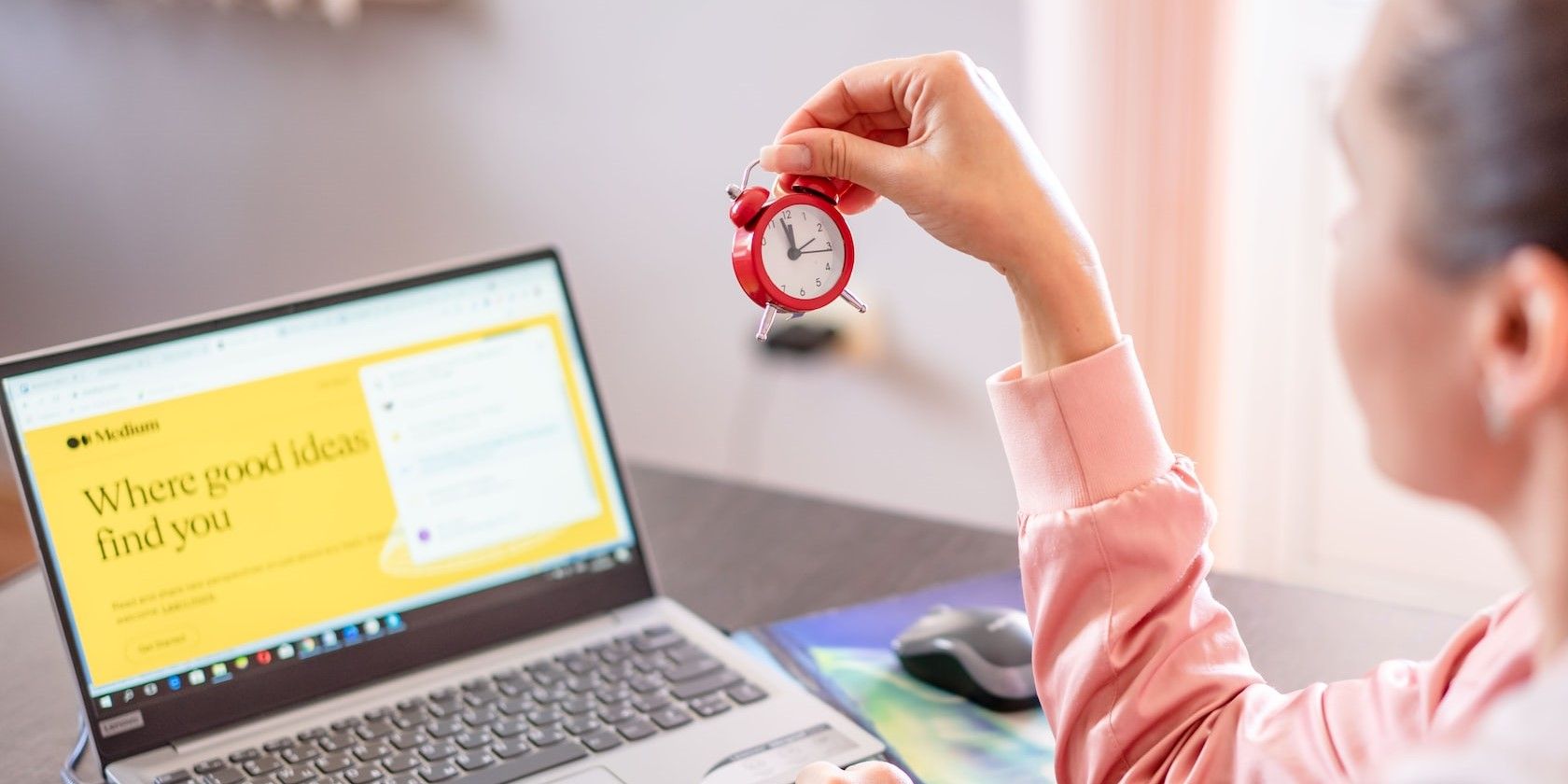 Woman Holding Clock in Front of Laptop Screen
