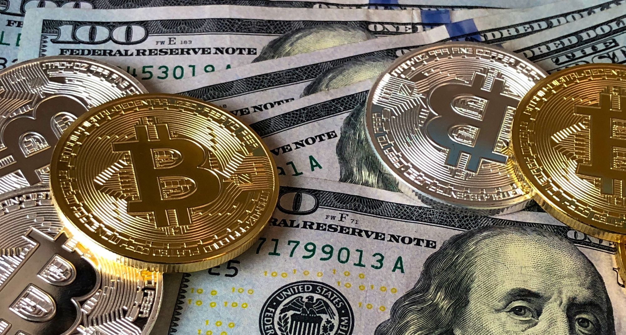 bitcoins lying on us hundred dollar bills 