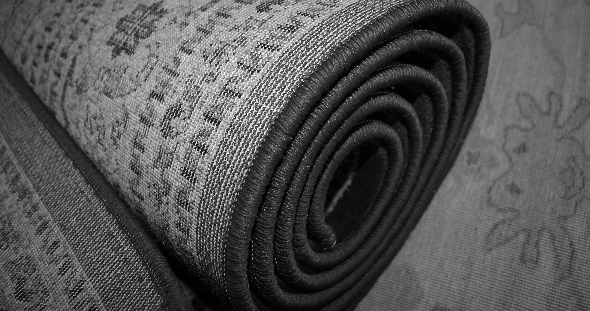 black and white photo of rug rolled up