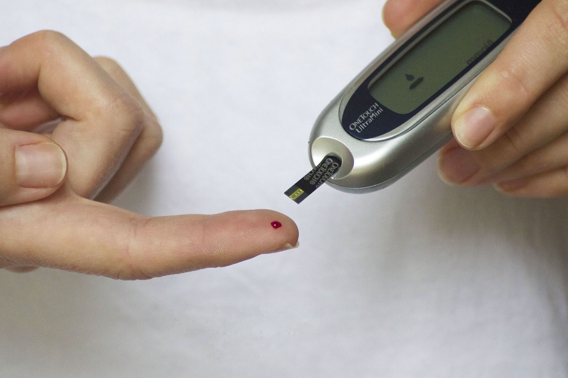 Tes diabetes dengan tester tusuk jarum dan jari yang ditusuk.