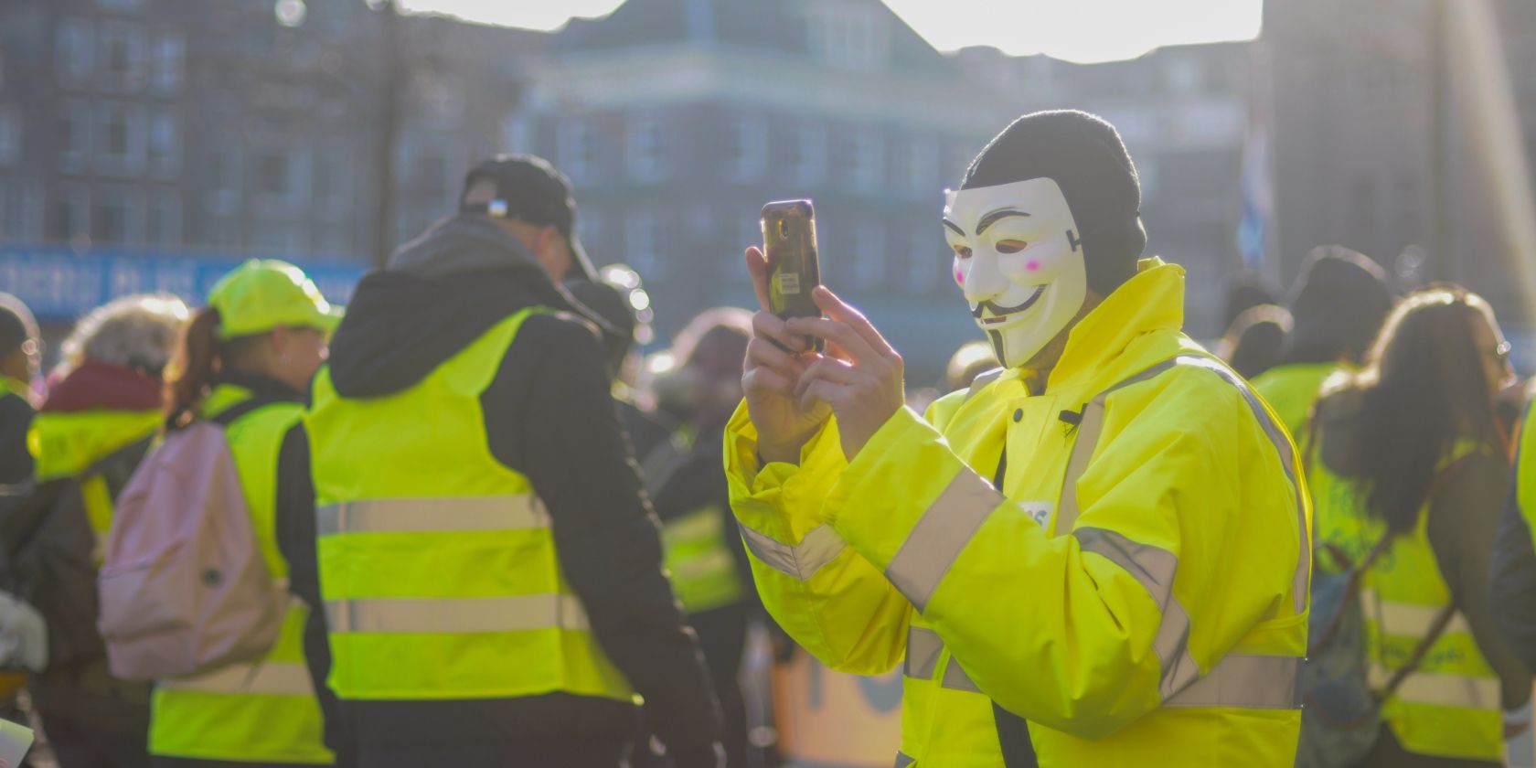 anonymous masked man taking photos