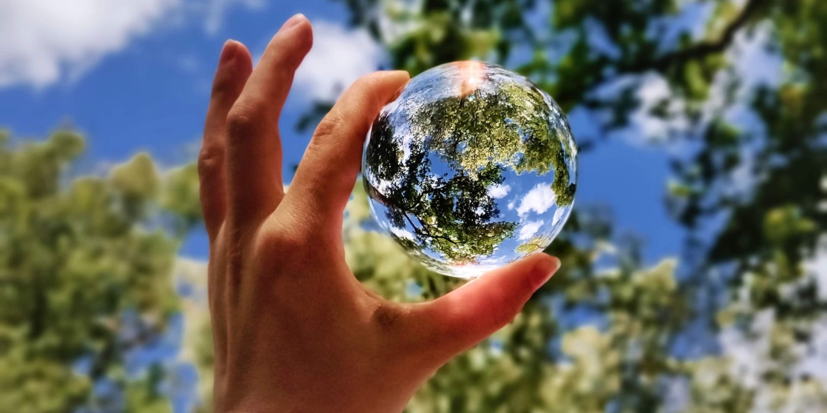 Hand Holding Up Glass Globe of Planet Earth