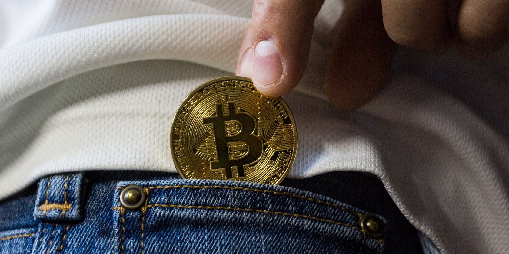 a picture of hand putting bitcoin in pocket