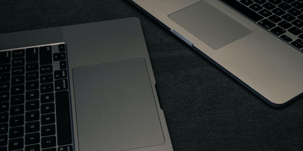 two macbooks with focus on the trackpad