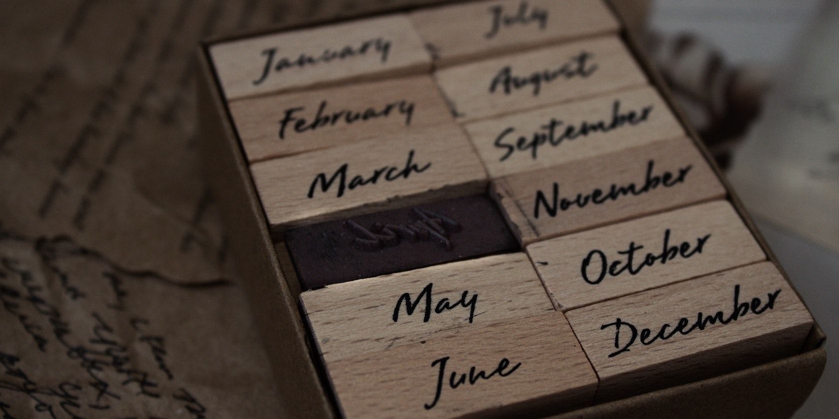 A wooden tray containing wooden blocks with the names of the months inked on.