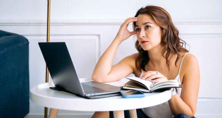 Woman looking at a laptop slightly upset