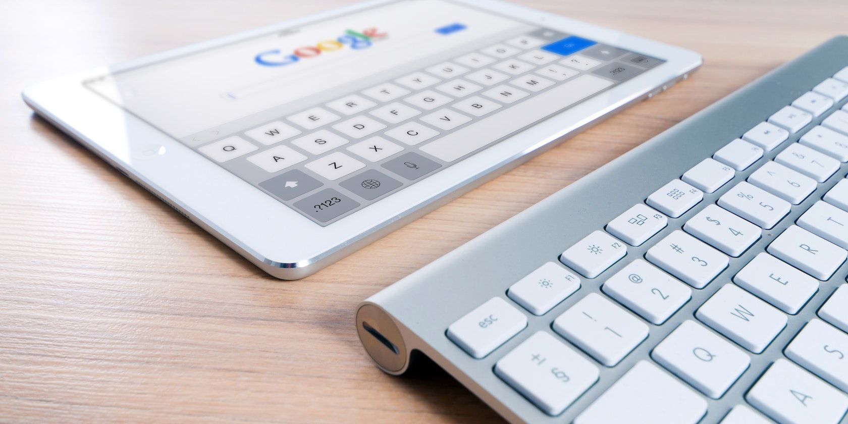 Keyboard and a tablet showing a blurred Google search page