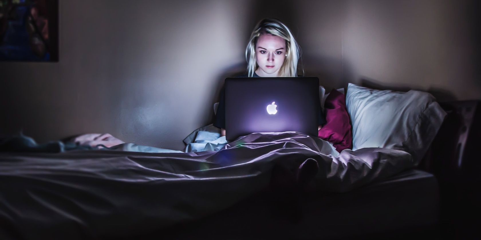 A woman working on her laptop in bed