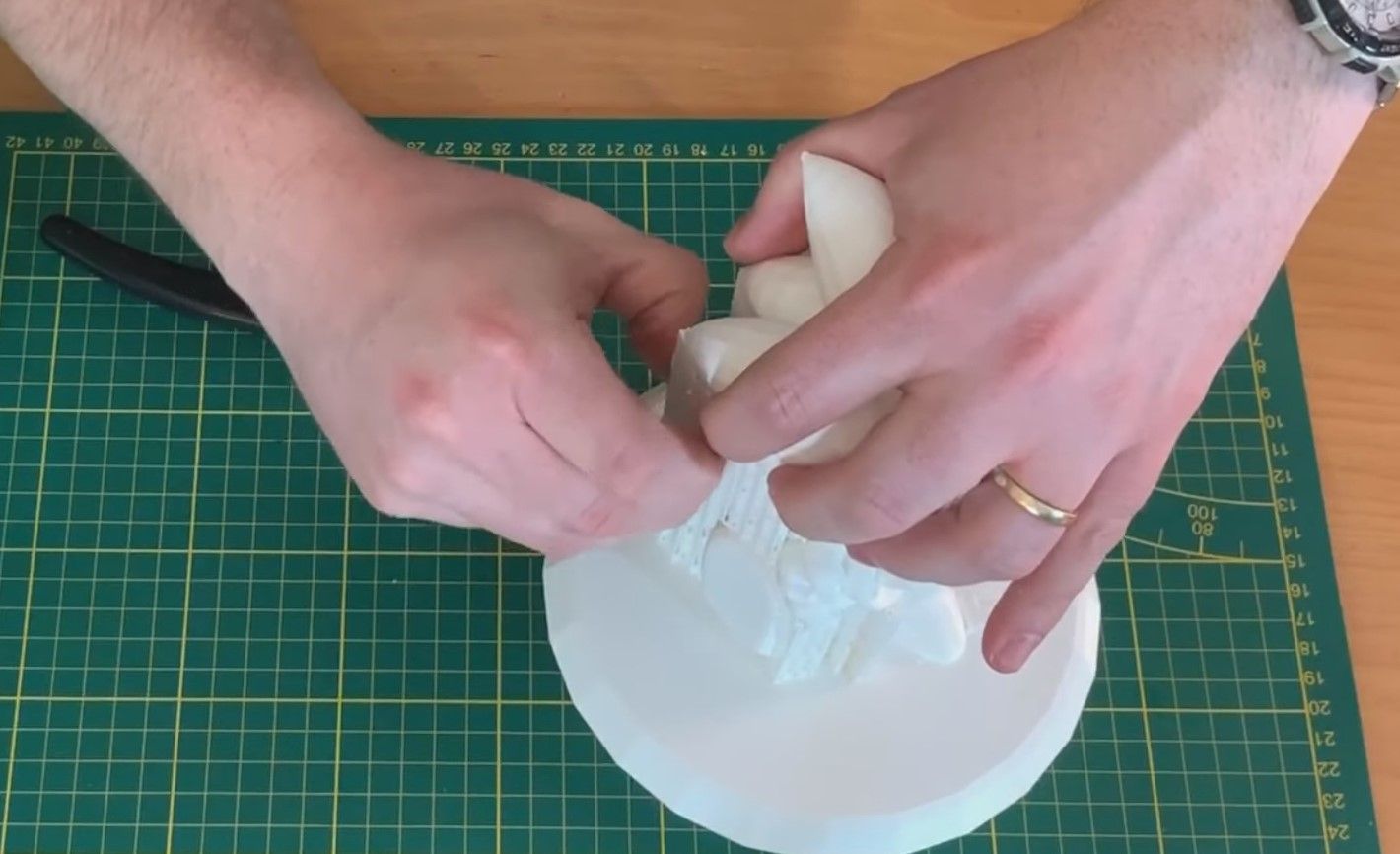 Hand of a white man removing supports from a model using his hands