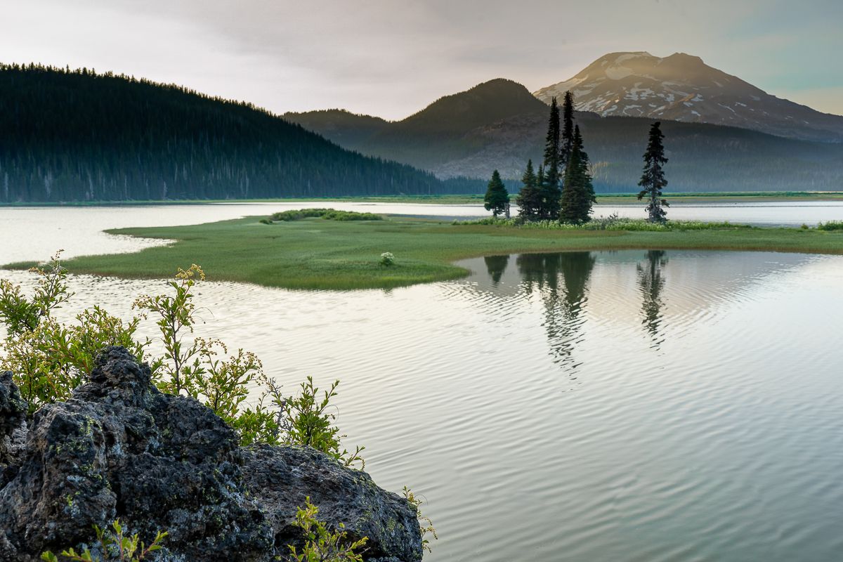 image of a rock in the foreground in focus and trees on the island in focus in Sparks Lake