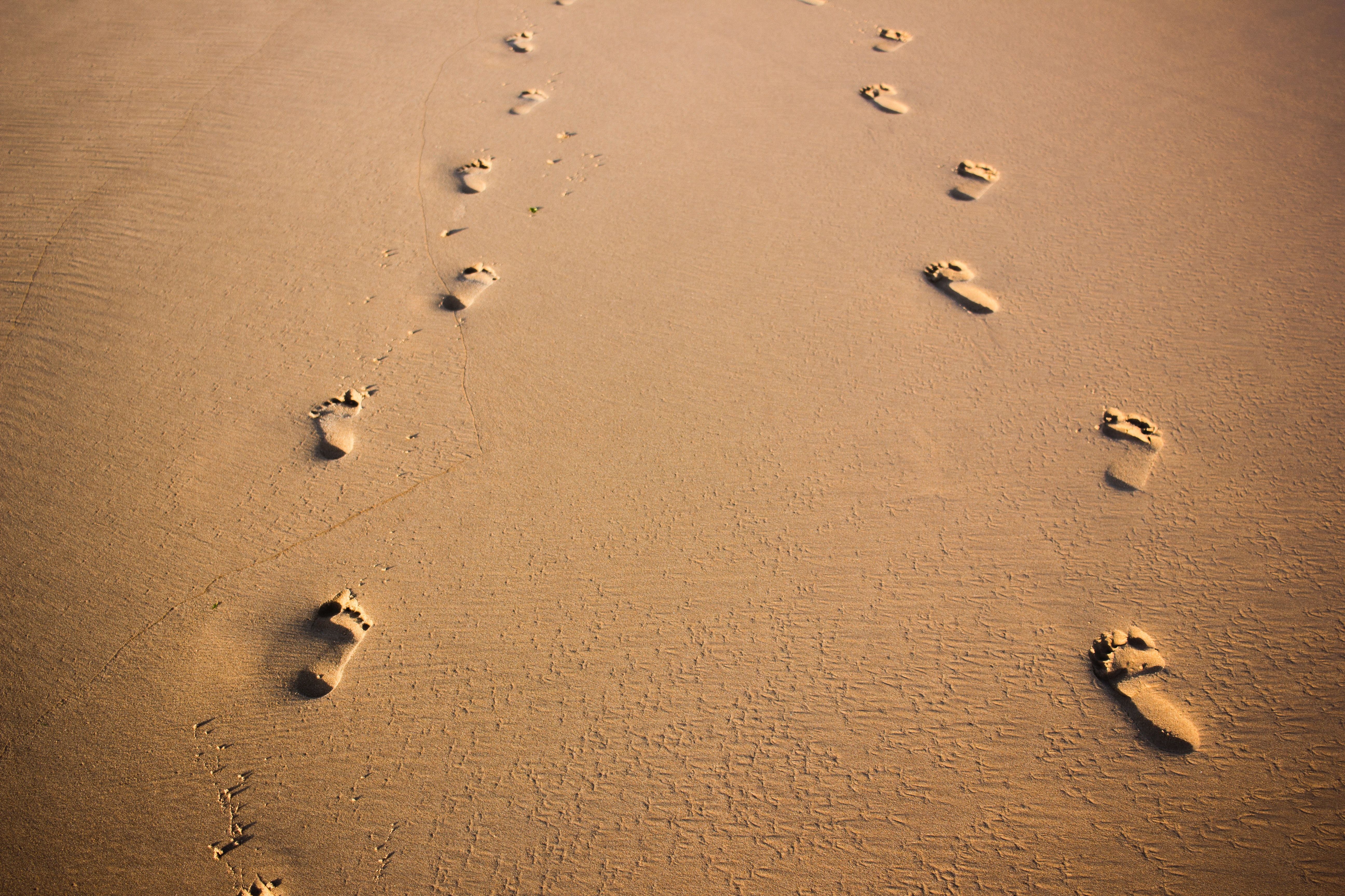 Two Pairs of Footprints Side by Side on the Beach
