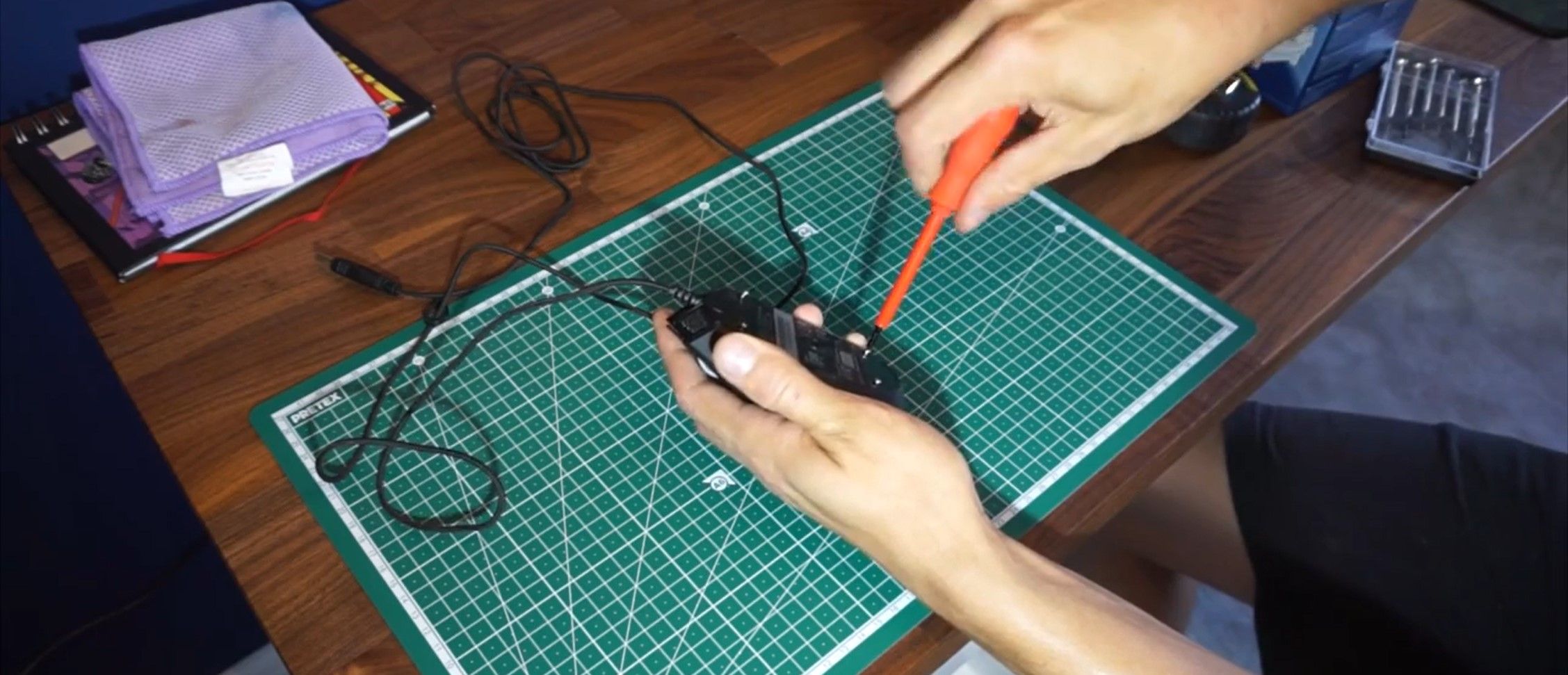 Person Unmounting the Screws to Disassemble the Mouse Casing