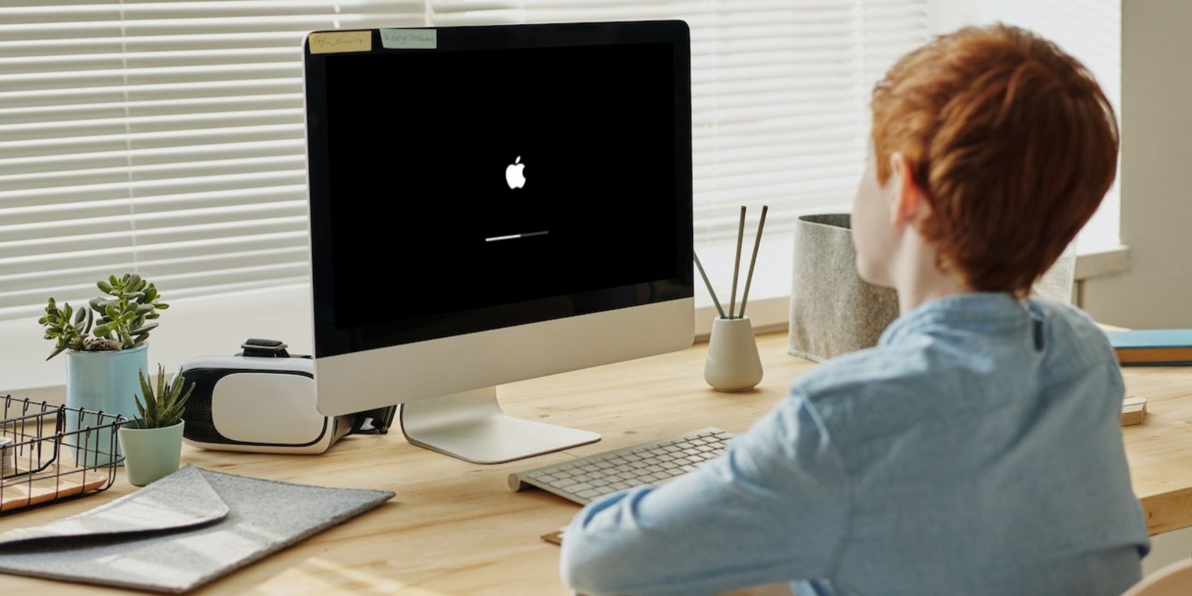 Anak laki-laki menonton layar pemuatan Apple di iMac