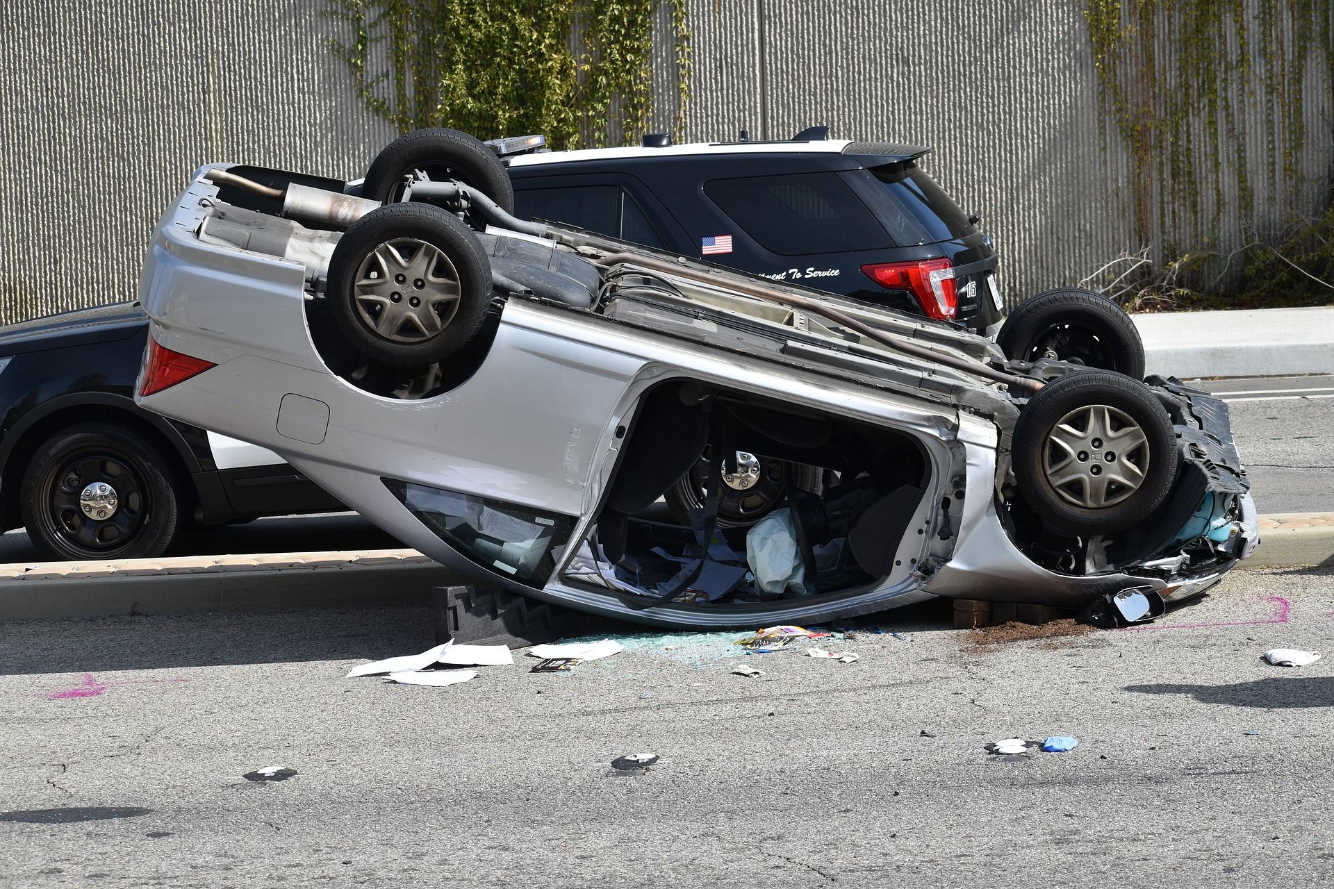 A grey Honda Civic coupe is in a serious accident that rolls it upside down