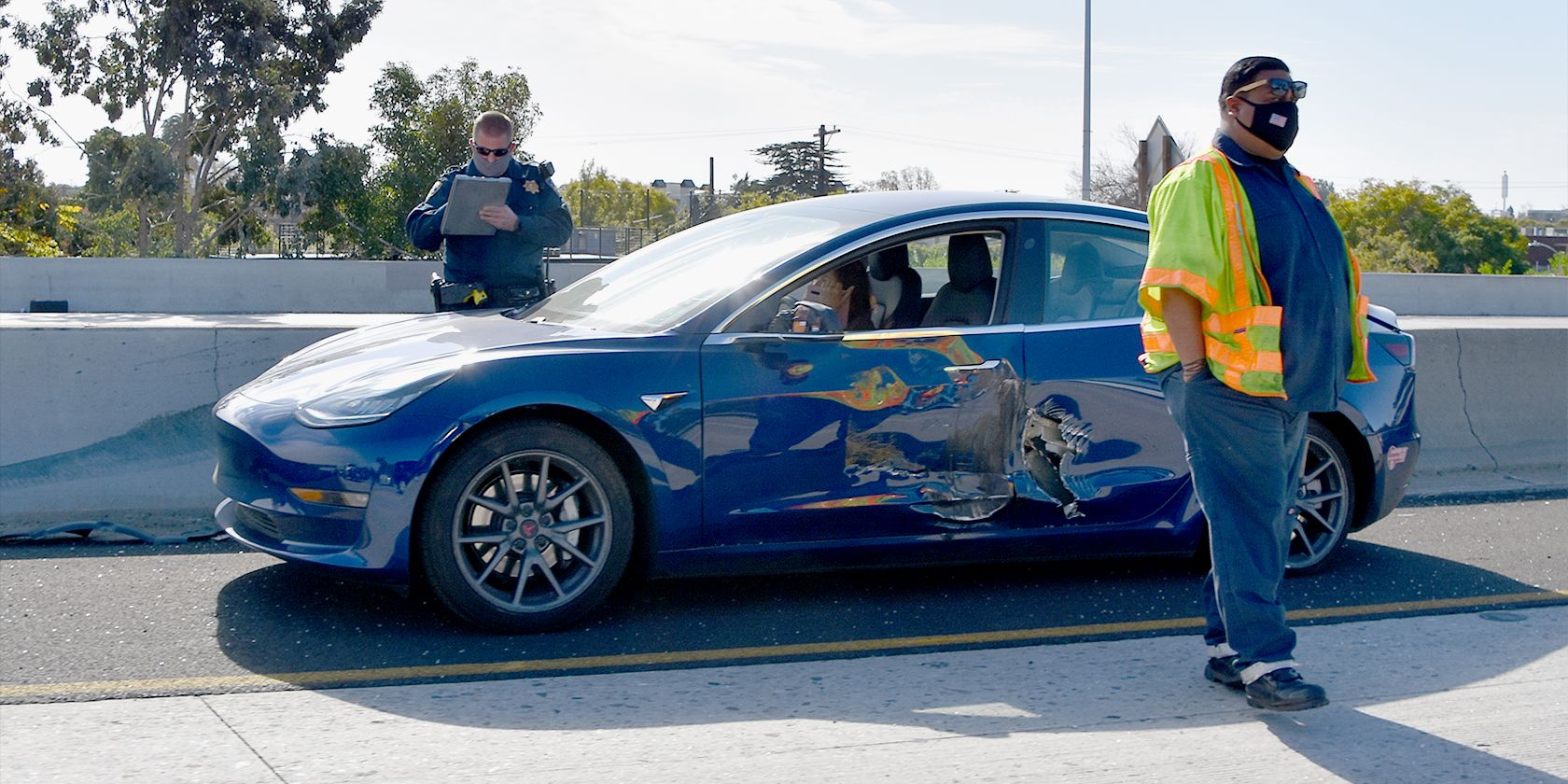 Crashed Tesla with Police Officer taking details