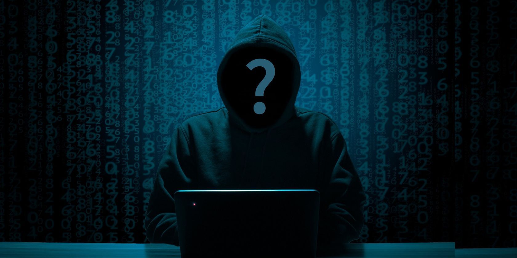 An anonymous cybercriminal, wearing a hoodie, working at a laptop. The scene is dark and the criminal facing us has a large question mark in front of their face.