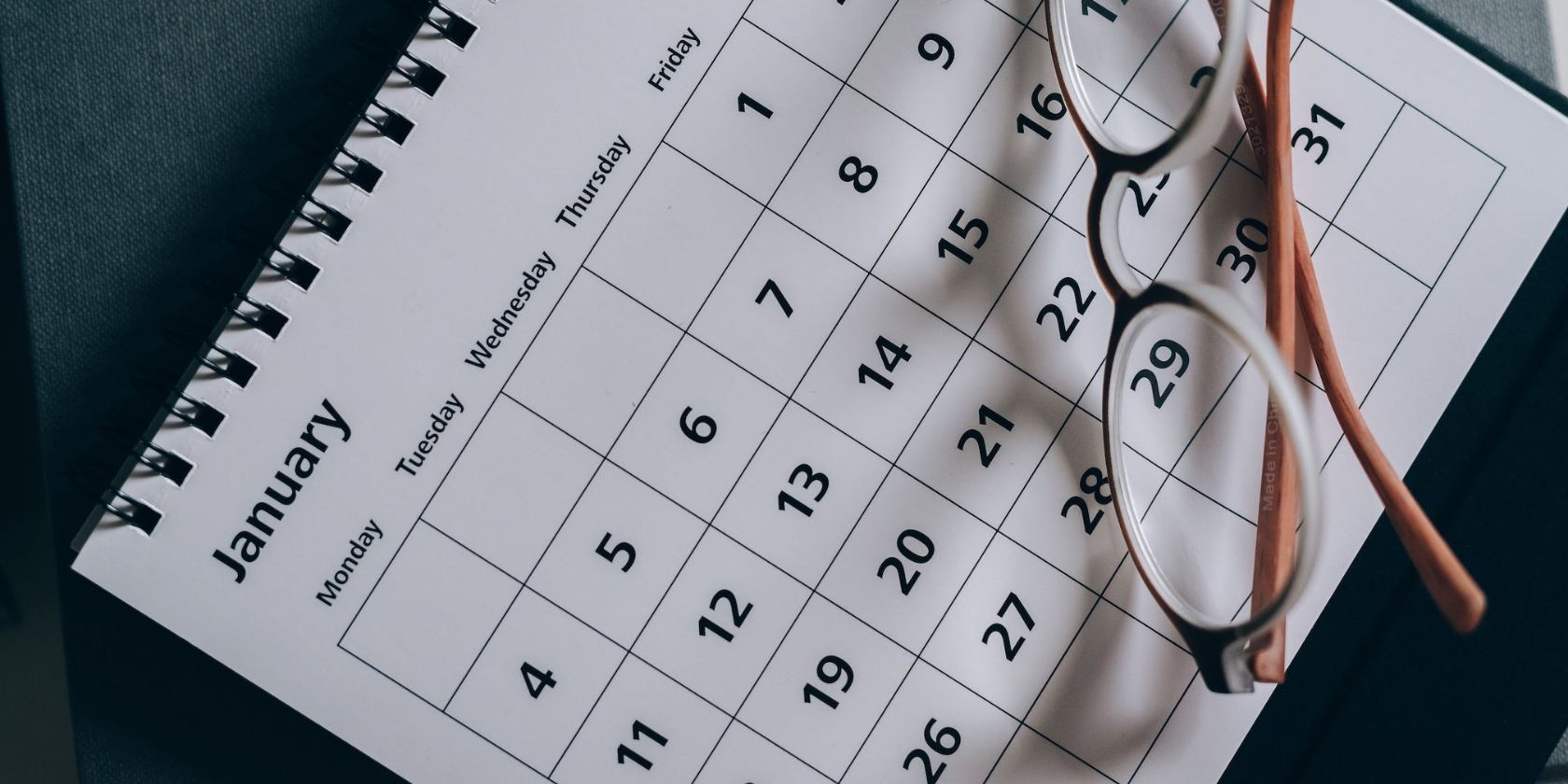 eyeglasses on white calendar showing month of january