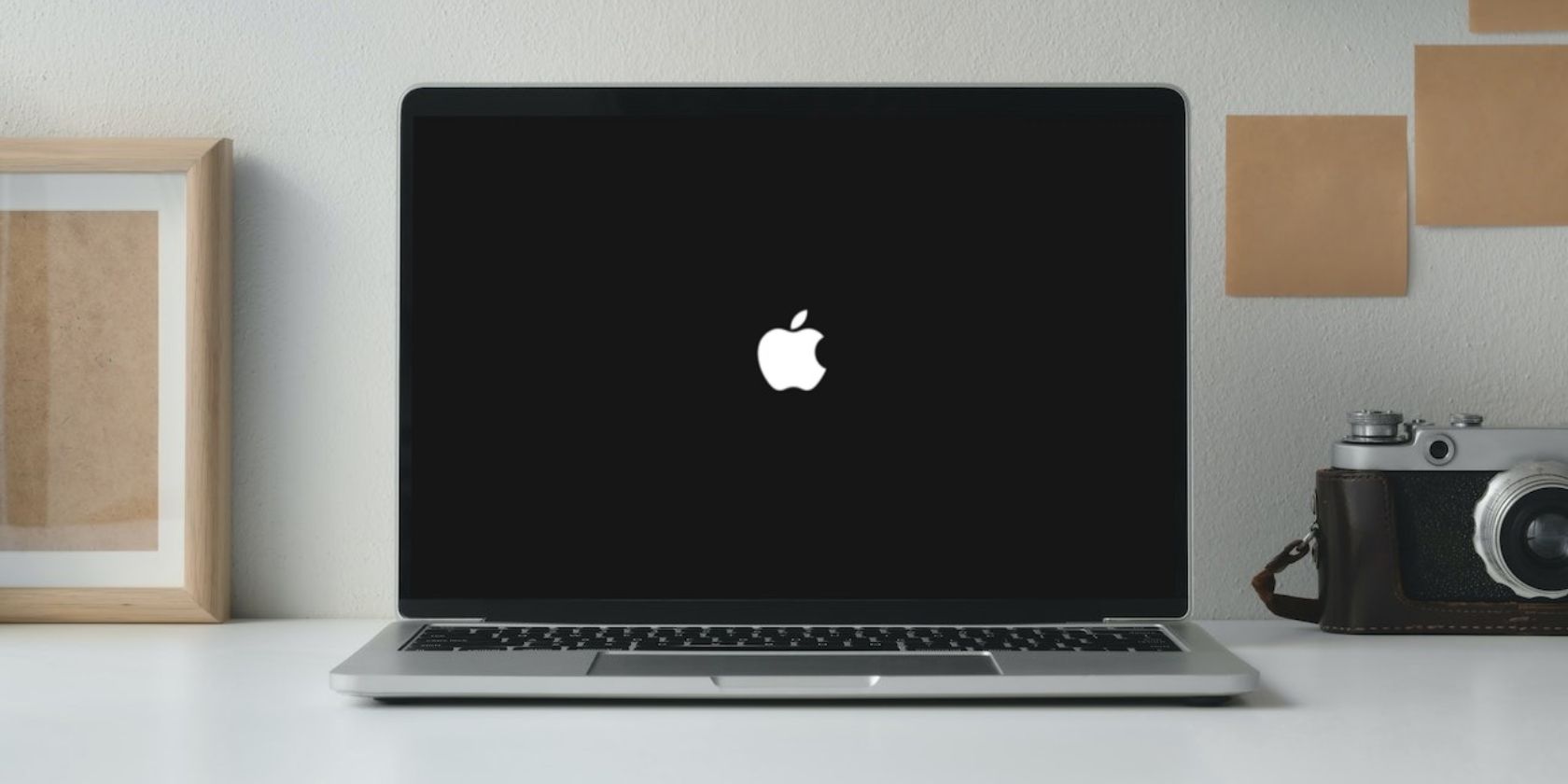 MacBook on a table with the Apple logo on screen