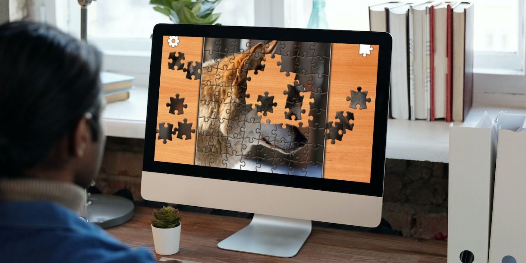 Man using iMac with jigsaw puzzle on screen