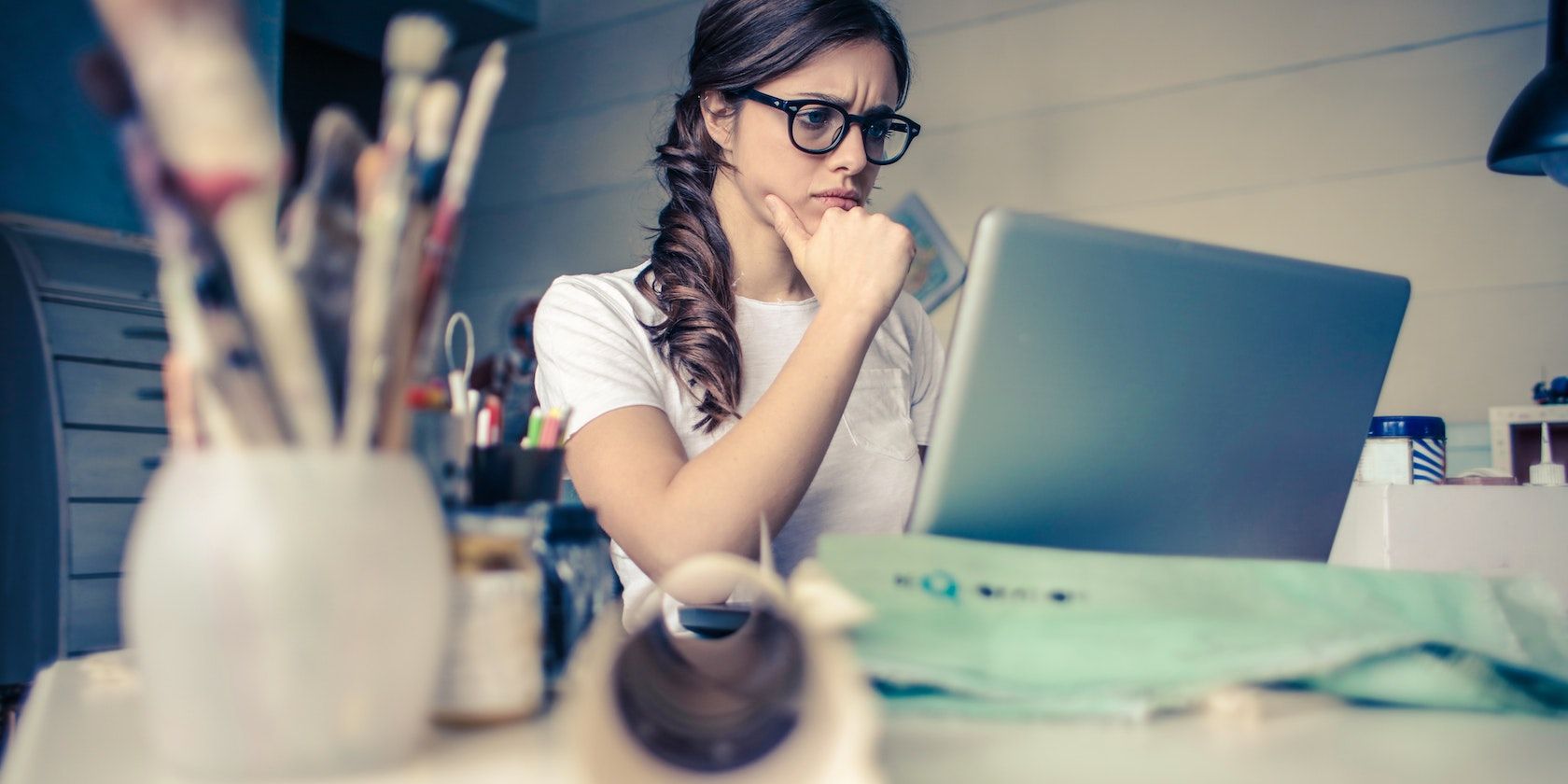 Foto seorang wanita menatap bingung ke laptop.