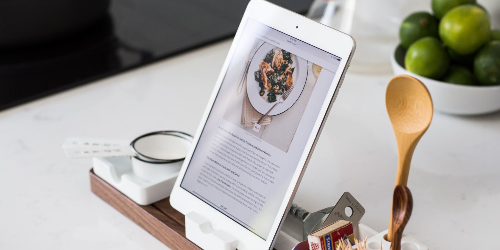 Tablet on a kitchen counter with a wooden spoon