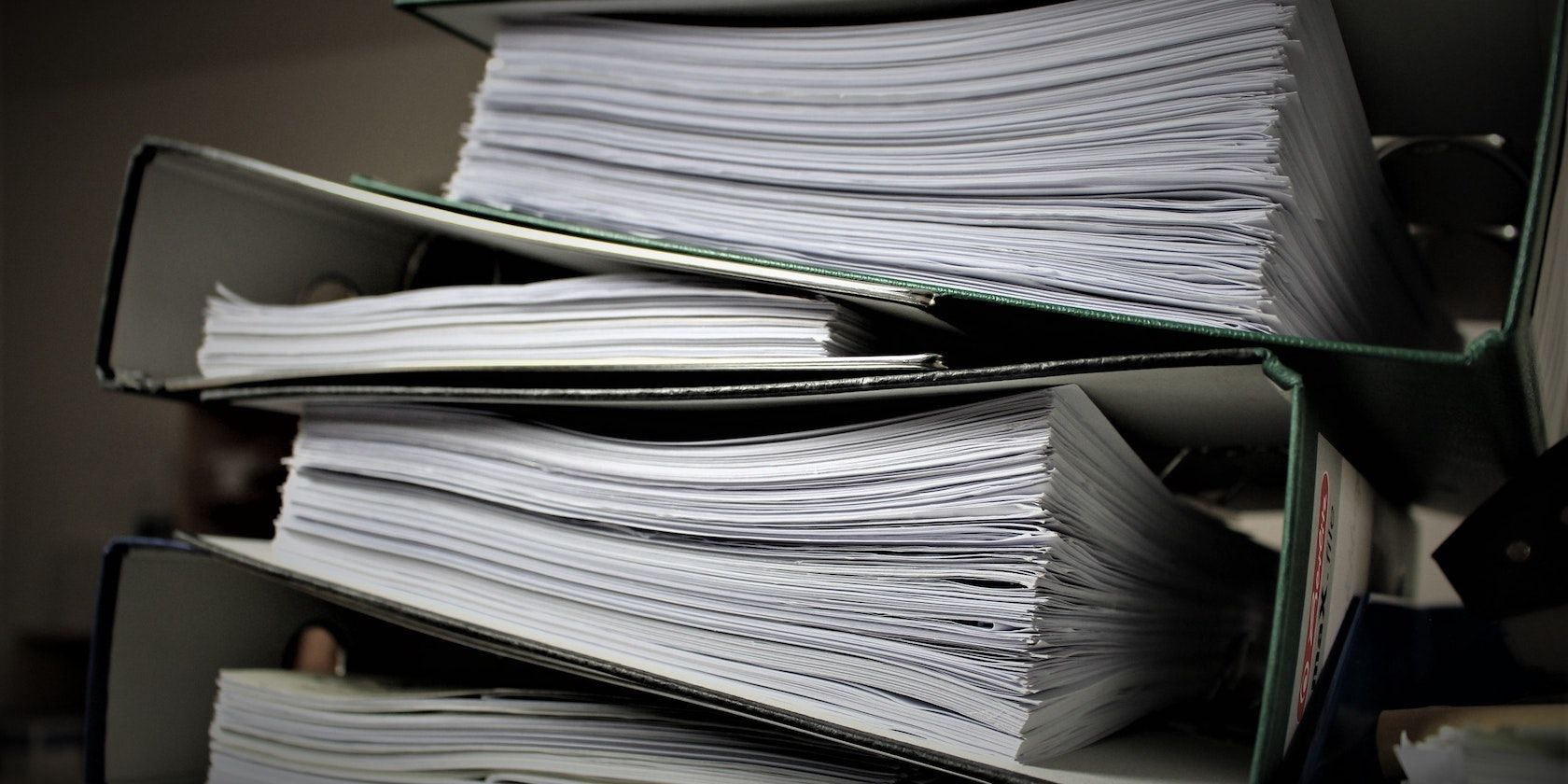 Stack of paperwork arranged in different folders.
