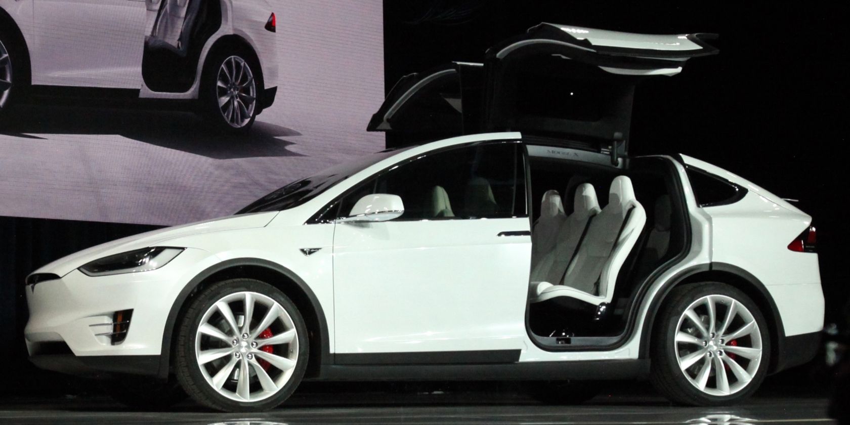 White Tesla Model X on stage with falcon doors raised