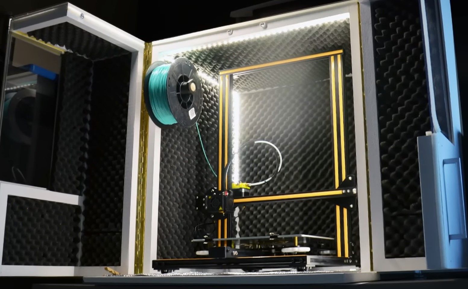 A 3D printer inside an enclosure that has been opened