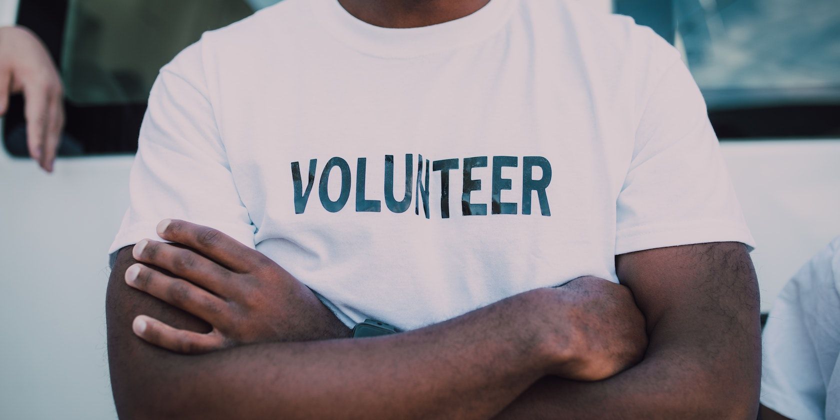 Um homem vestindo uma camiseta que diz voluntário.