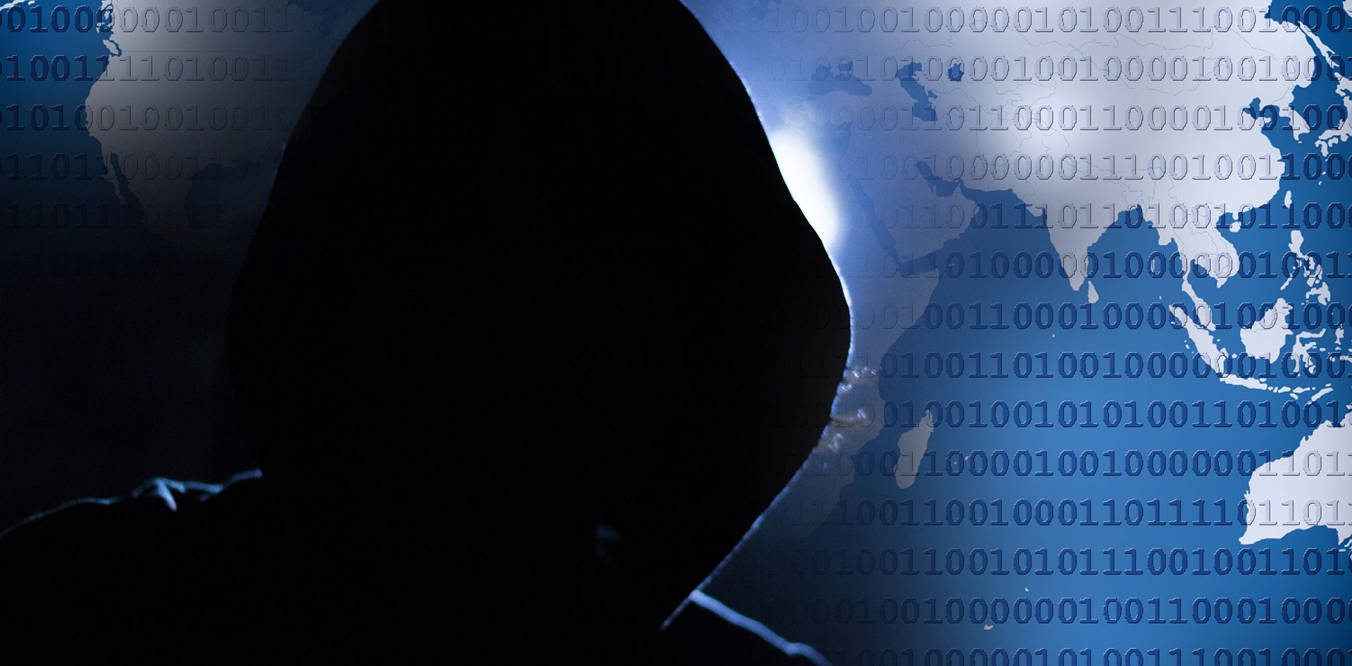 anonymous hooded figure in front of binary code map background