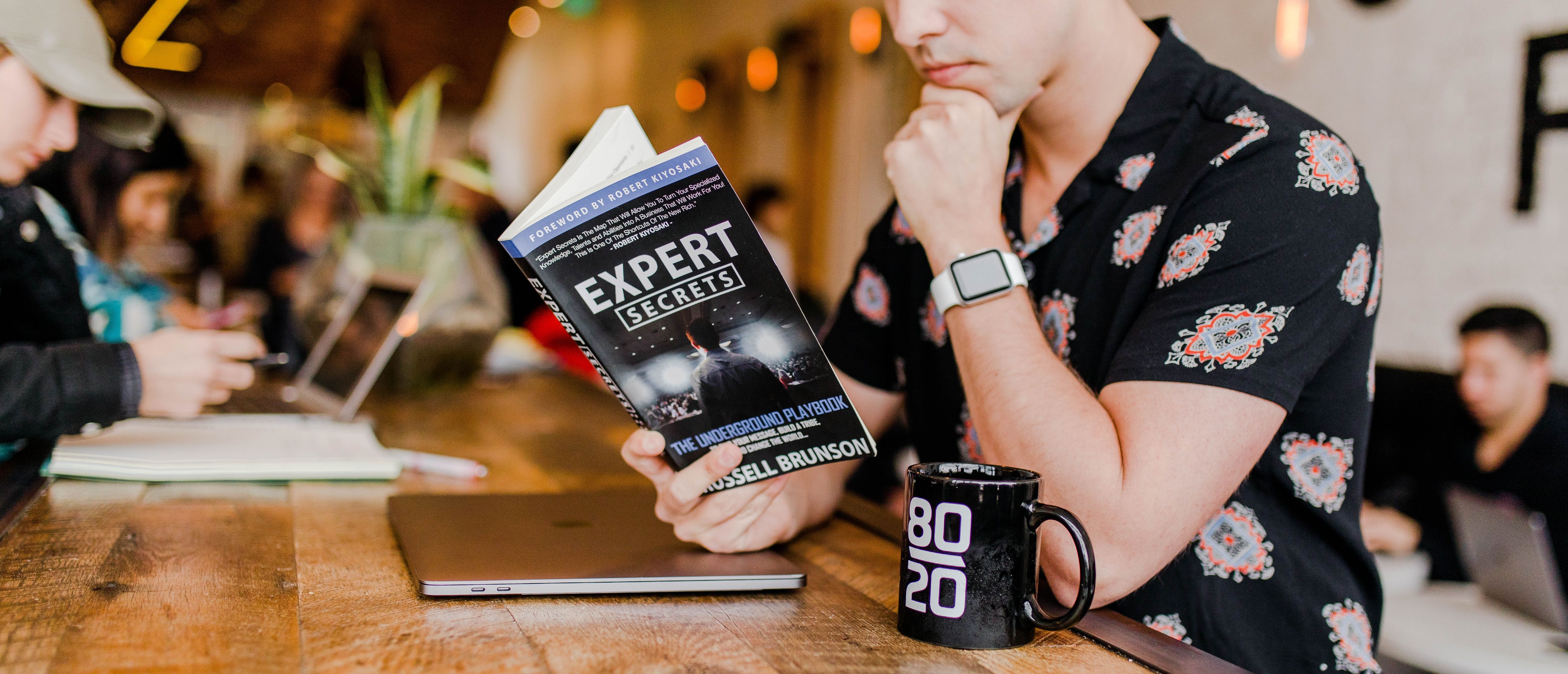 Man reading Expert Secrets Book