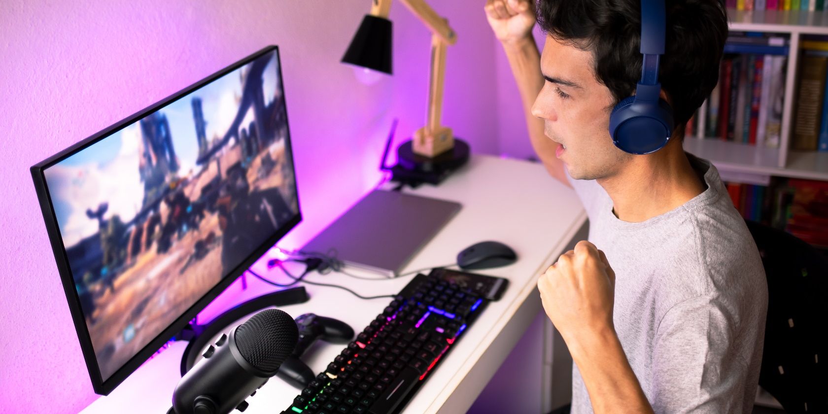 man cheering at game on computer monitor