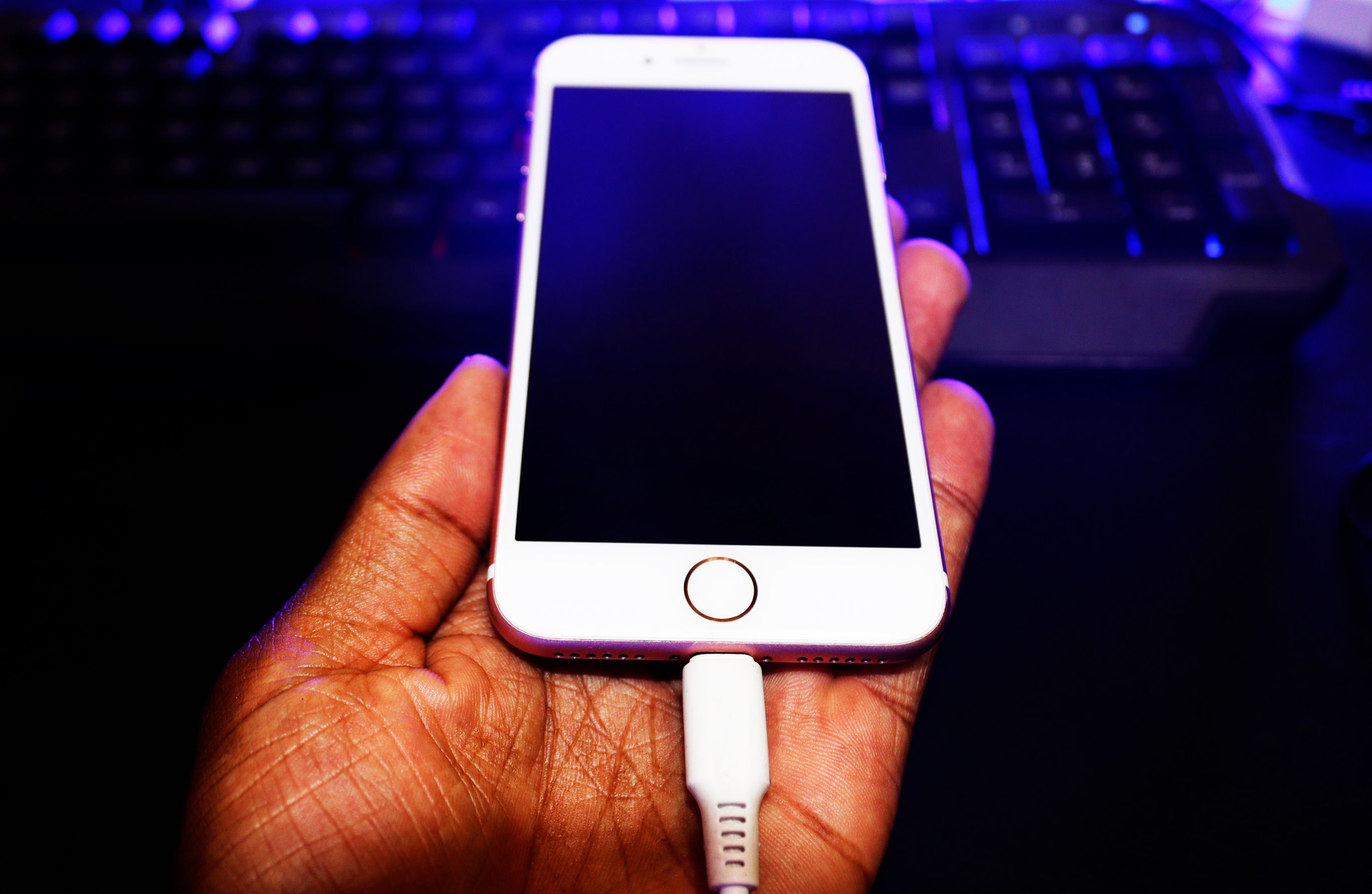 Un iPhone est tenu dans la main avec le chargeur inséré