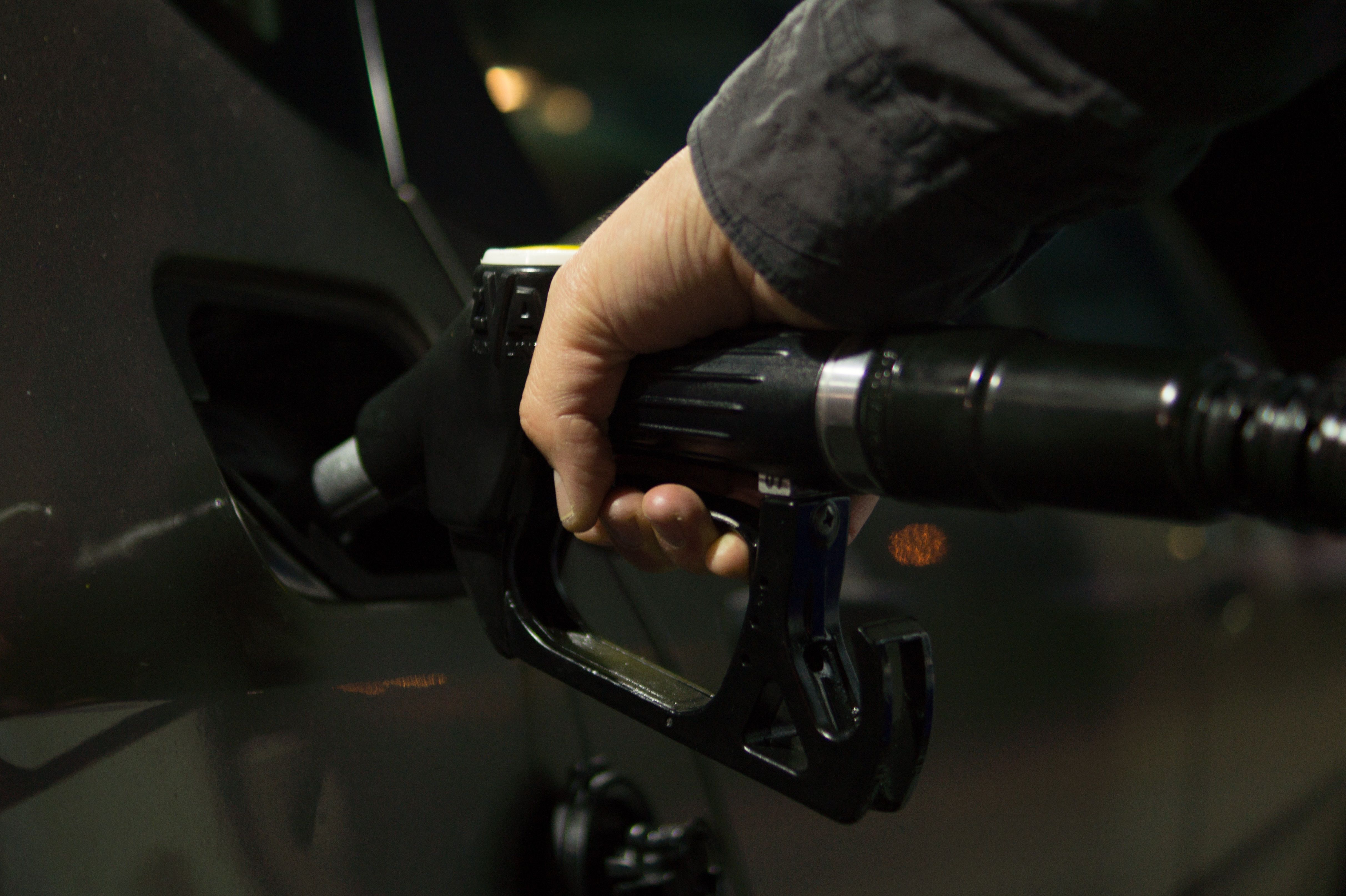 A man holds a fuel nozzle
