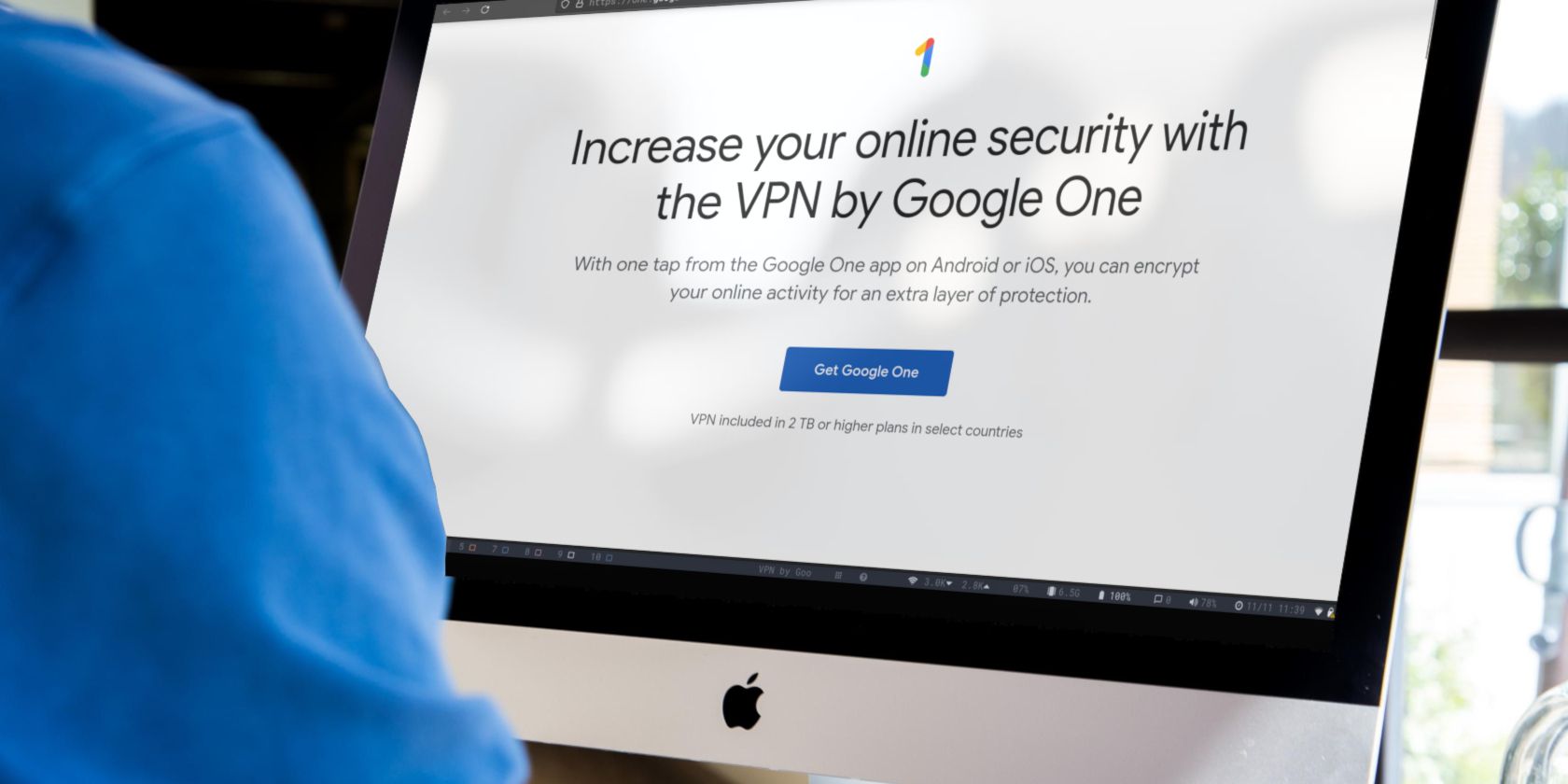 person in a blue shirt using an imac to look at the web page for google vpn imac