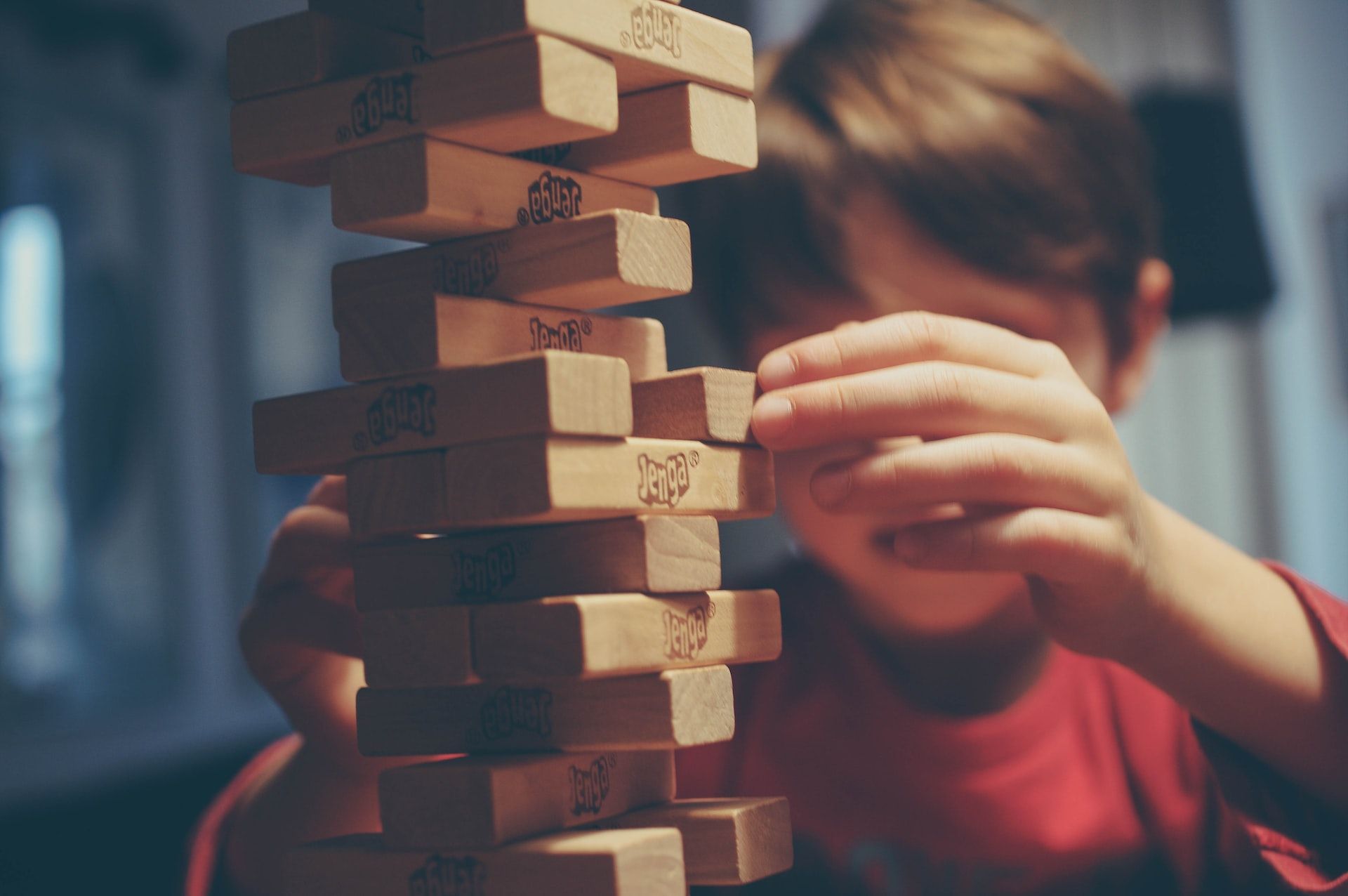 A kid playing with a Jenga Tower