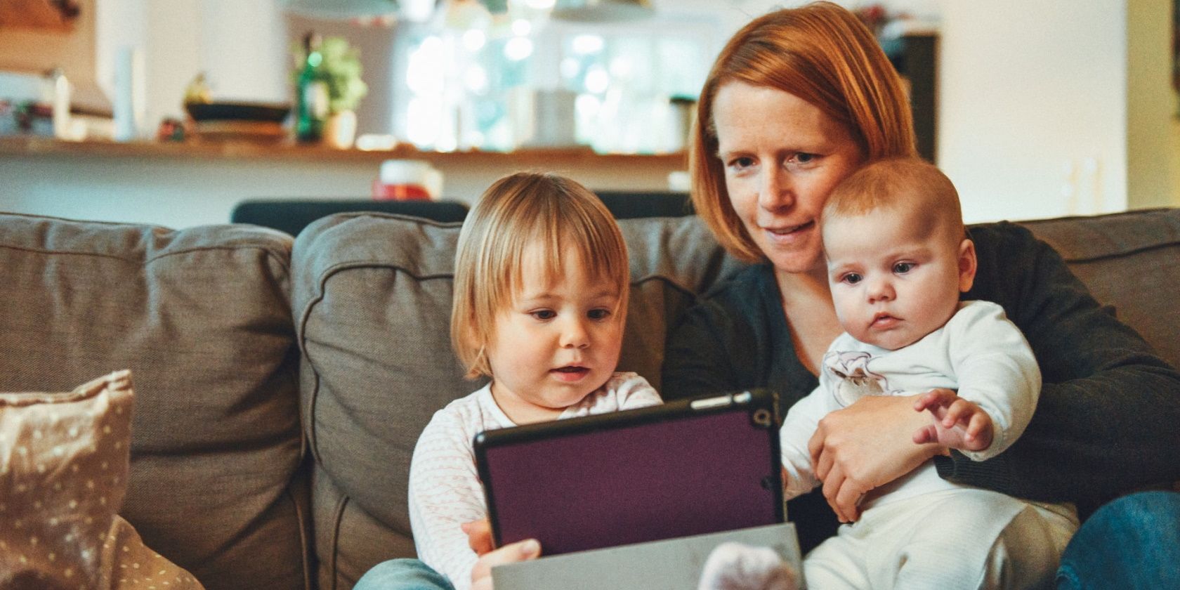 Mother playing on a tablet with her two small children