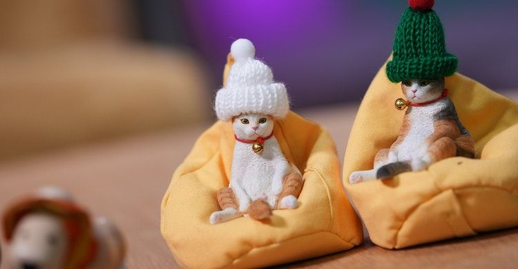 Toy cat figurines wearing Christmas hats