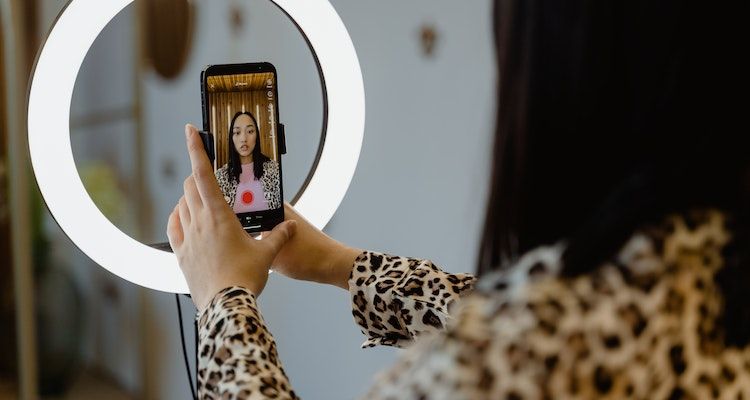 A woman using a smartphone to record herself