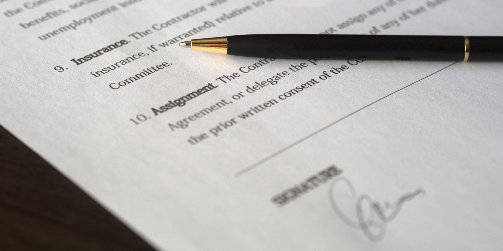 Black pen on top of signed employment agreement